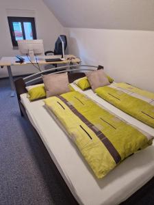 1 dormitorio con 2 camas con sábanas amarillas y escritorio en Ferienwohnung Zentrum Luckau, en Luckau