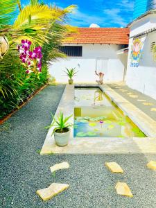 a garden with a pond in the middle of a house at Emma's Sea View in Hiriketiya