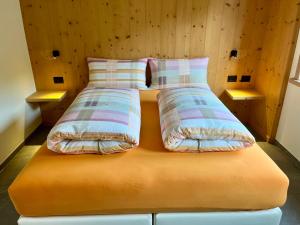 a bed with two pillows on top of it at Chalet Girasole in Livigno