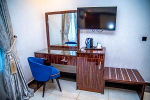 a desk with a mirror and a blue chair in a room at Fritz Apartments & Suites in Abuja