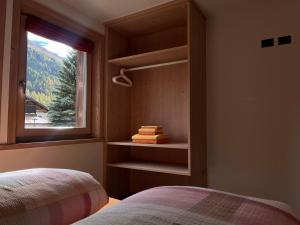 リヴィーニョにあるChalet Girasoleのベッドルーム1室(ベッド2台付)、景色を望む窓が備わります。