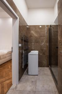 プラハにあるDlážděná Apartmentsのバスルーム(トイレ、シャワー付)、ベッド1台が備わります。