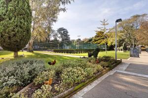 un parque con pollos en un jardín de flores en Cozy and Vintage Apartment, en Carcavelos