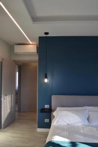 a bedroom with a blue accent wall and a bed at Fenocchio's House in Castiglione Falletto