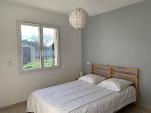 a bedroom with a large bed with a window at Maison 6 pers, climatisée, quartier calme, proche Dune du Pyla et pistes cyclables, ménage inclus - FR-1-319-426 in Parentis-en-Born
