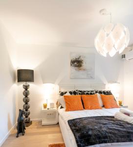 una camera da letto con un grande letto con cuscini arancioni di La gazza ladra a Namur