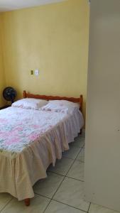 Una cama grande en una habitación con colcha. en Casa de praia para família - 3 quartos - acomoda até 10 pessoas en Tramandaí