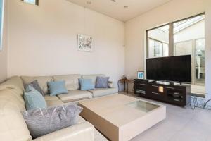 a living room with a couch and a flat screen tv at Okusawa Private House in Tokyo