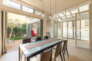 ein Esszimmer mit Glastisch und Stühlen in der Unterkunft Okusawa Private House in Tokio