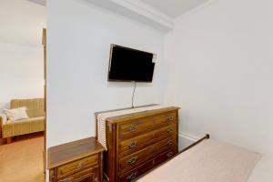 Habitación con tocador y TV en la pared. en Cozy and Vintage Basement en Carcavelos