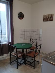 tavolo e sedie in cucina con tavolo verde di Le Cormoran a Le Tréport
