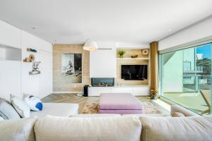 a living room with white furniture and a large window at Panoramic Views - Terrace, Sea Views & Pool in Nazaré