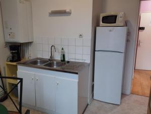 uma cozinha com um lavatório e um frigorífico branco em Le Cormoran em Le Tréport