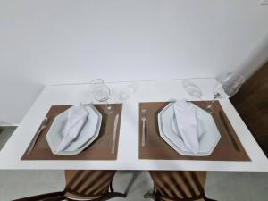 a table with a white shirt and glasses and shoes at Excelente Flat beira-mar in Cabedelo