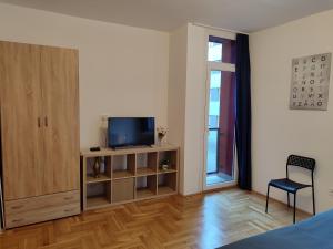 a living room with a tv and a wooden cabinet at Castle Corner Apartment in Budapest