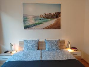 a bedroom with a bed with a picture on the wall at Castle Corner Apartment in Budapest