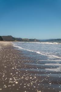 una playa de arena con burbujas en el agua en Cabaña Curaquilla - Arauco, en Arauco