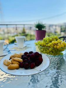 un plato de comida en una mesa con uvas y galletas en Το σπίτι της Ειρήνης κοντά στην Κνωσσό en Áno Fortétsa