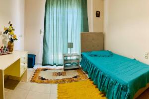 Un dormitorio con una cama azul y una ventana en Το σπίτι της Ειρήνης κοντά στην Κνωσσό en Áno Fortétsa