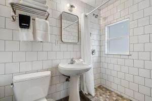 a white bathroom with a toilet and a sink at Selkirk Motel in Colville +32 photos
