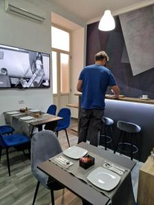 Ein Mann, der an einer Theke in einem Raum mit Tischen steht. in der Unterkunft B&B City Center in Neapel