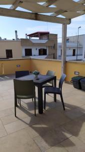une table et des chaises noires sur un toit dans l'établissement Casa Vacanze STELLA MARINA, à Torre San Giovanni