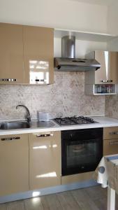 une cuisine avec un évier et une cuisinière four supérieur dans l'établissement Casa Vacanze STELLA MARINA, à Torre San Giovanni