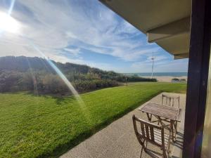 a bench on a porch with a view of a field at Studio Zeedijk Koksijde in Koksijde