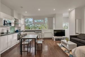 a kitchen and living room with a table and a couch at Cosy & Modern Studio in London