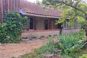 a small house with flowers in front of it at Logement entier chez Hélène in Sainte-Gemme-Martaillac
