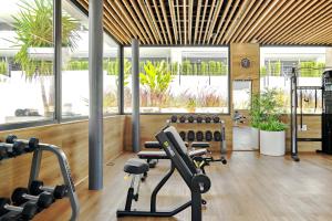 a gym with cardio equipment in a room with windows at Apartament Flamenca Village Lime & Lemon in Orihuela Costa