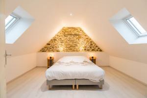 sypialnia na poddaszu z łóżkiem i świetlikami w obiekcie Manoir de Kervegan : Le Logis du Grand Couchant w mieście Lannion