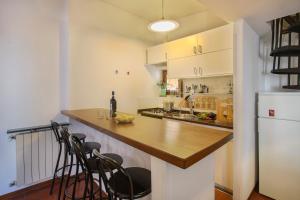 a kitchen with a counter with chairs and a refrigerator at L'Attico di Sant'Ambrogio in Florence