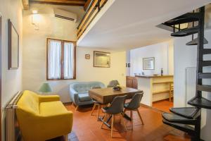 a living room with a table and chairs and a kitchen at L'Attico di Sant'Ambrogio in Florence