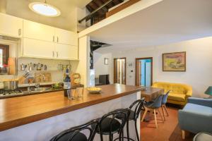 a kitchen and living room with a counter and chairs at L'Attico di Sant'Ambrogio in Florence