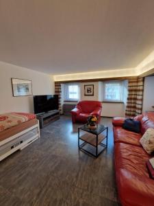 uma sala de estar com um sofá e uma televisão em Haus Rizzi em Bivio