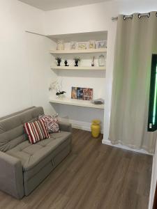 a living room with a couch and shelves at Loft Residencial GreenPark by Staya in Brasilia