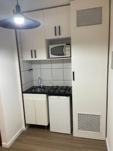 a small kitchen with a sink and a microwave at Loft Residencial GreenPark by Staya in Brasilia