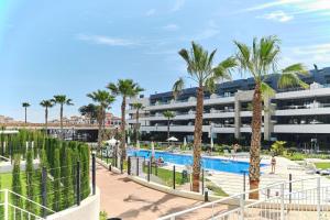 a view of a resort with a pool and palm trees at Apartament Flamenca Village Lime & Lemon in Orihuela Costa
