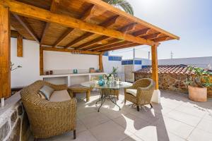 patio con tavolo, sedie e pergolato in legno di Panoramic View Villa Chayofa a Chayofa