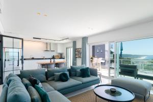 een woonkamer met een bank en een tafel bij Panoramic Views - Terrace, Sea Views & Pool in Nazaré