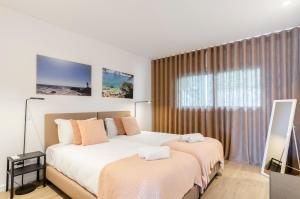 a bedroom with two beds and a large window at Panoramic Views - Terrace, Sea Views & Pool in Nazaré