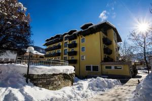 Un edificio con nieve delante en Hotel Pinzgauerhof by Alpeffect Hotels, en Zell am See