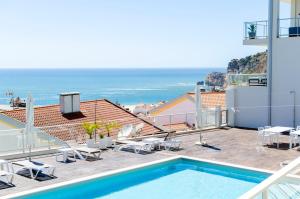een balkon met een zwembad en de oceaan bij Panoramic Views - Terrace, Sea Views & Pool in Nazaré +34 foto's