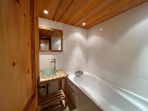a bathroom with a bath tub and a sink at Apartment Les Rousses 3 minutes from Alpe dHuez Grand Domaine via Oz en Oisans in Oz +11 photos