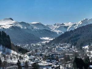 a town in a valley with snow covered mountains at Appartement Mont-Dore, 2 pièces, 4 personnes - FR-1-415-129 in Le Mont-Dore