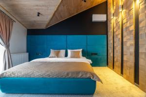 1 dormitorio con cabecero azul y 1 cama en Greitser Elit Chalet, en Bukovel
