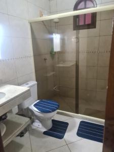 bagno con servizi igienici e doccia con tappetini blu di Recanto do Valdir ad Angra dos Reis Altre 19 foto