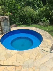 una grande piscina blu su un patio in pietra di Recanto do Valdir ad Angra dos Reis