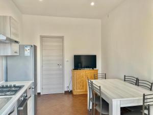 cocina con mesa y TV en la pared en Alloggio TOBIA en Biella
